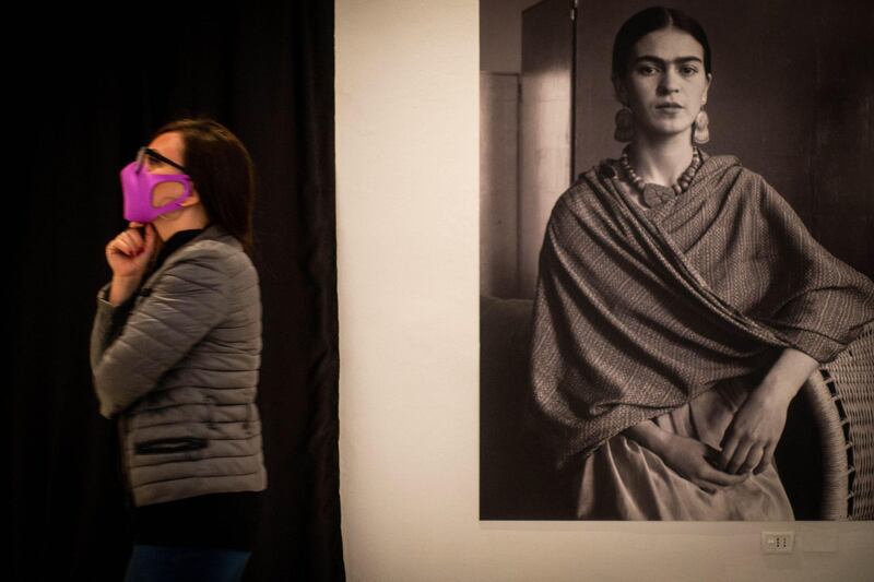 A visitor walks by a picture of Frida Kalho on display in the exhibition dedicated to the Mexican artist at the Palazzo delle Arti in Naples, Italy. EPA