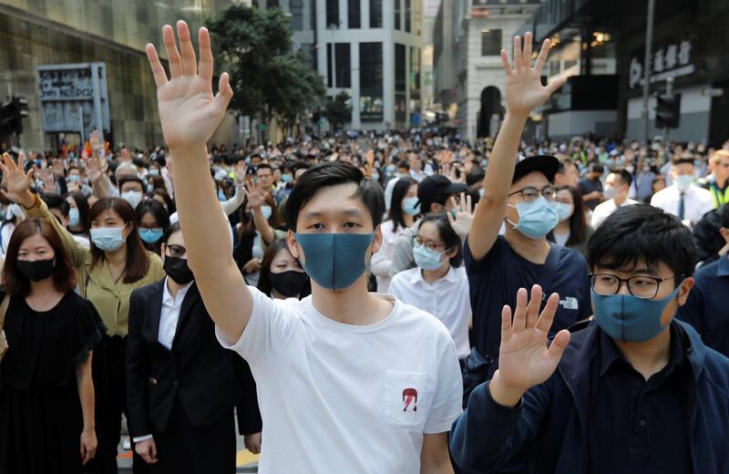 Demonstrators in Hong Kong's the Central District raise their hands with fingers extended to refer to their five demands. Reuters
