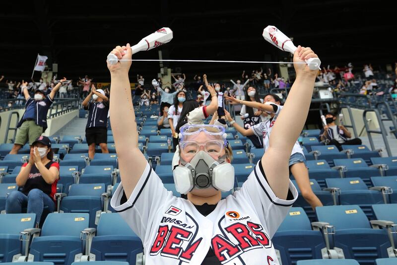 A fan cheers during the KBO league game between Doosan Bears and LG Twins in Seoul, South Korea, on Sunday. Authorities began bringing back spectators in professional sports games amid the coronavirus pandemic.  AP