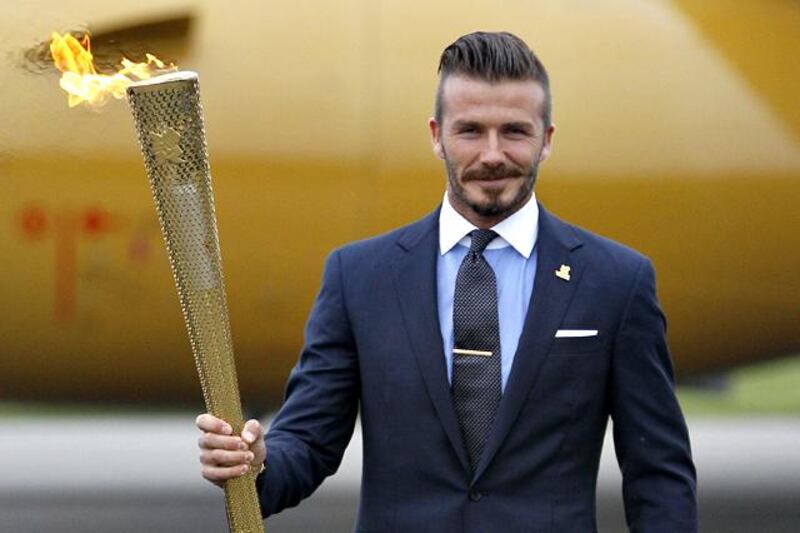 Britain's David Beckham holds the Olympic torch during the ceremony to mark the arrival of the Olympic flame to Britain from Greece, at RNAS Culdrose, Cornwall, England, Friday May 18, 2012. (AP Photo/Alastair Grant)