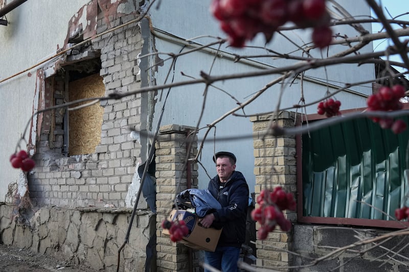 A man removes his belongings from his house after it was struck by artillery shells in Novoluhanske, eastern Ukraine. AP