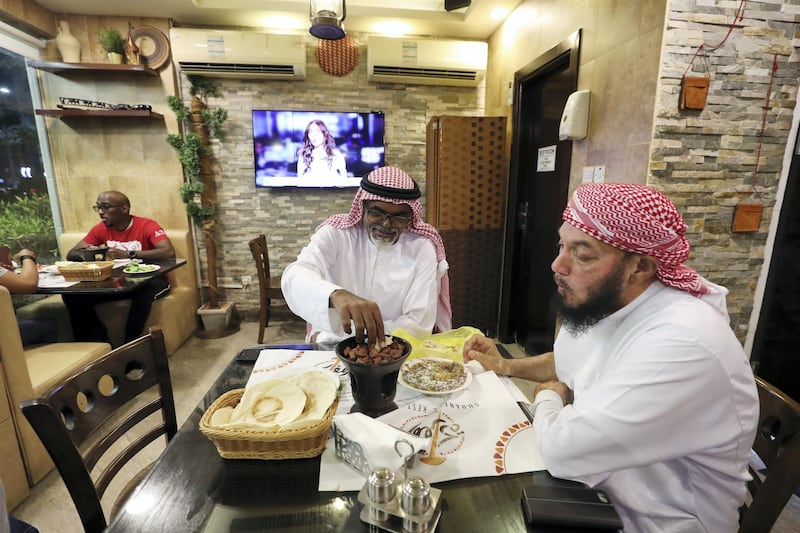 Abu Dhabi, United Arab Emirates - July 24, 2019: Two gentlemen enjoy their dinner. Al Mufraka restaurant, one of Abu DhabiÕs small number of Sudanese restaurants. Wednesday the 24th of July 2019. Abu Dhabi. Chris Whiteoak / The National