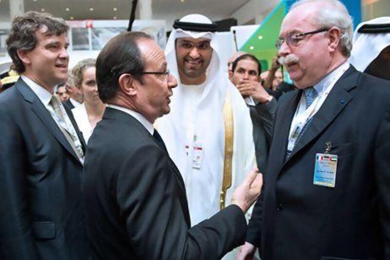 Francois Hollande, the president of France, greets Christophe de Margerie, the chief executive of Total, with Sultan Ahmed al-Jaber, the chief executive of Masdar, at the World Future Energy Summit 2013 in Abu Dhabi. Bertrand Langlois / AFP