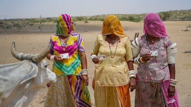 Women pose with their identity cards in the desert village of Jaiisindhar, western Rajasthan state, India. AP