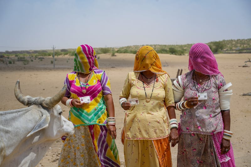 Women pose with their identity cards in the desert village of Jaiisindhar, western Rajasthan state, India. AP