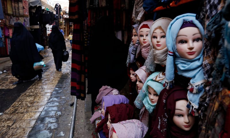 Women with burqa pass mannequins in Muslim headscarf hijab, at a market in Sanaa, Yemen.  EPA