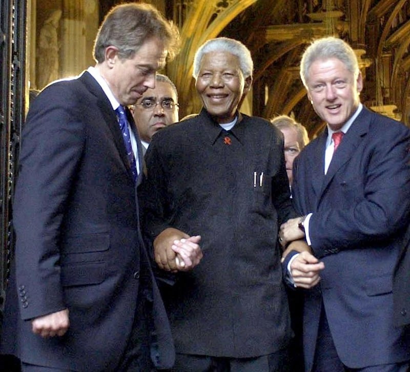 Former South African president Nelson Mandela is assisted by the former British prime minister Tony Blair and former US president Bill Clinton after attending a Gala night in London on July 2, 2003. Chris Young / Reuters