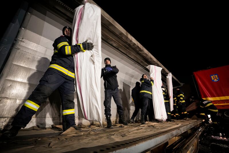 Romanian firefighters load a Turkey-bound train with emergency aid near Bucharest. AP