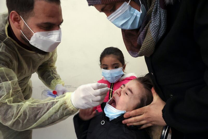 A Palestinian Health Ministry medic takes a swab sample from a child to test for the coronavirus in the village of Dura, west of Hebron, in the Israeli-occupied West Bank. AFP