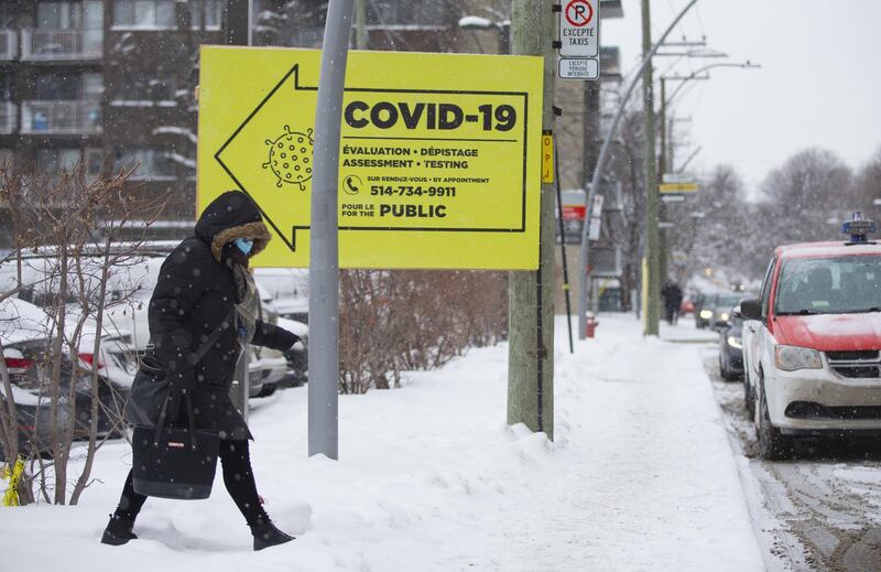 A pedestrian passes in front of a sign for a Covid-19 testing site in Montreal, Quebec, Canada, on Thursday, Jan. 21, 2021. Even though Canada has secured more vaccines per capita than any other nation, "it doesn't mean much" when the bulk is not yet being delivered, an epidemiologist at the University of Toronto said. Photographer: Christinne Muschi/Bloomberg
