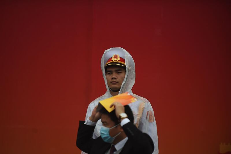 A man wearing a protective facemask walks pass a policeman in Hanoi. AFP