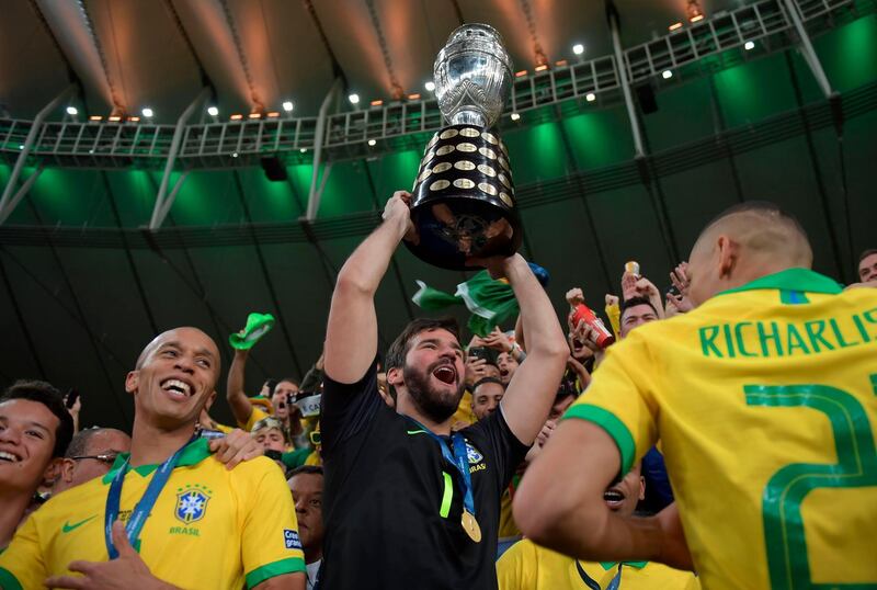 Brazil's goalkeeper Alisson raises the trophy. AFP