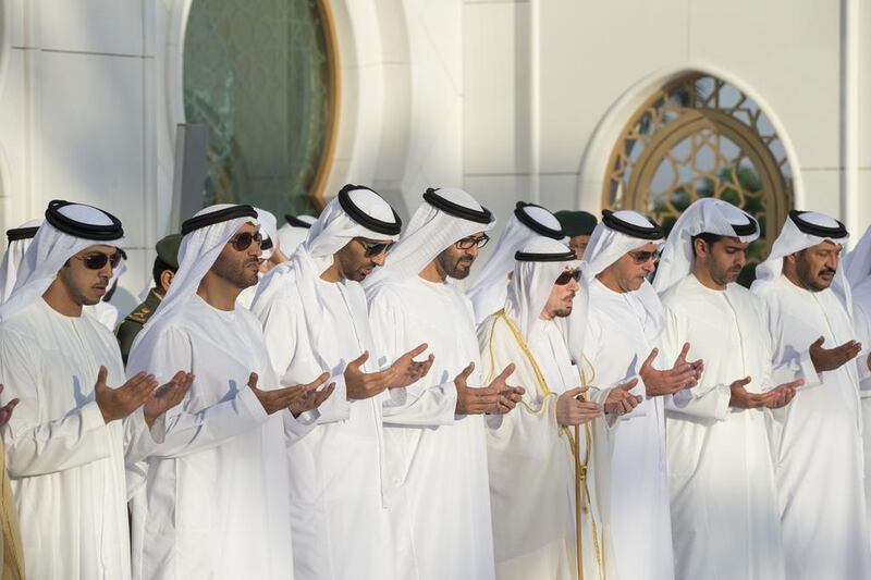 Sheikh Mohammed bin Zayed, centre, Crown Prince of Abu Dhabi and Deputy Supreme Commander of the Armed Forces, prays at the tomb of his late father Sheikh Zayed after Eid Al Adha prayers yesterday at the Sheikh Zayed Grand Mosque in Abu Dhabi.  Ryan Carter / Crown Prince Court – Abu Dhabi