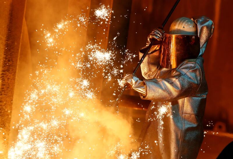 FILE PHOTO: A steel worker of ThyssenKrupp stands amid sparks of raw iron coming from a blast furnace at a ThyssenKrupp steel factory in Duisburg, western Germany, January 30, 2020. REUTERS/Wolfgang Rattay/File Photo