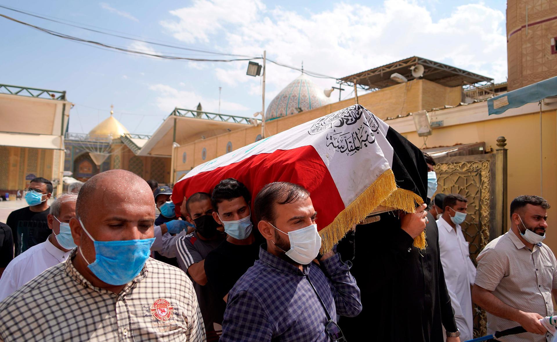 Mourners carry the coffin of slain Iraqi security expert Husham Al Hashimi, before his burial in Najaf, central Iraq. AFP