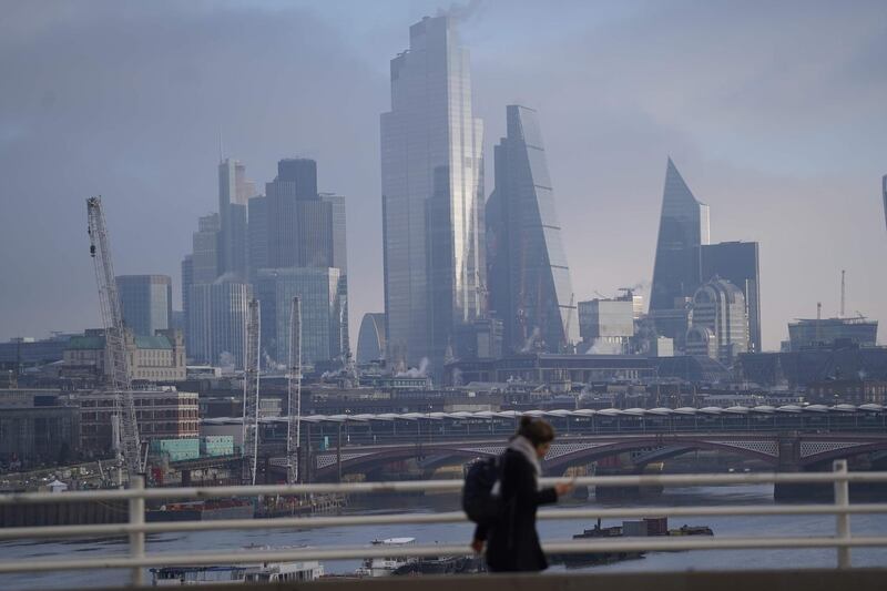 Pedestrians walk along a bridge over the River Thames with skyscrapers and offices of the City of London in the background in London on December 31, 2020 on the day that the Brexit transition period ends and Britain leaves the EU single market and customs union four-and-a-half years after voting to leave the bloc.                         Brexit becomes a reality on on December 31 as Britain leaves Europe's customs union and single market, ending nearly half a century of often turbulent ties with its closest neighbours. The UK's tortuous departure from the European Union takes full effect when Big Ben strikes 11:00 pm (2300 GMT) in central London, just as most of the European mainland ushers in 2021 at midnight.
 / AFP / Niklas HALLE'N
