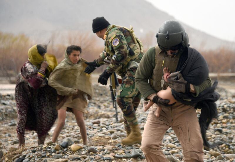 An Afghan air force crew member carries a child during an evacuation operation in a flood affected area of Arghandab district in Kandahar province. AFP