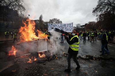 TOPSHOT - Protesters build a barricade during a protest of Yellow vests (Gilets jaunes) against rising oil prices and living costs, on December 1, 2018 in Paris.   / AFP / Abdulmonam EASSA
