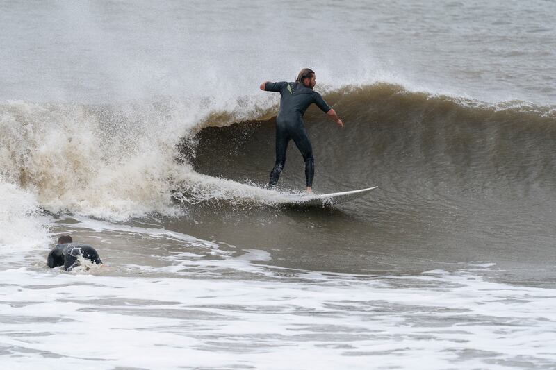 A surfer rides a wave following Hurricane Ian in Folly Island, South Carolina. AP