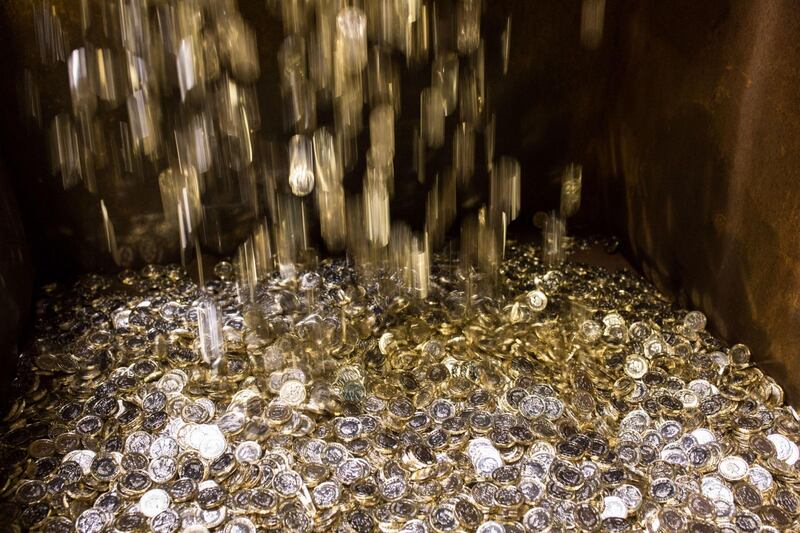 New British one pound coins drop into a container during their production at The Royal Mint in Llantrisant, U.K., on Thursday, March 23, 2017. Photographer: Jason Alden/Bloomberg