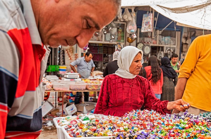 A woman shops for sweets at the main market of the Kurdish-majority city of Qamishli in Syria's northeastern Hasakeh province on May 19, ahead of Eid. Delil Souleiman / AFP