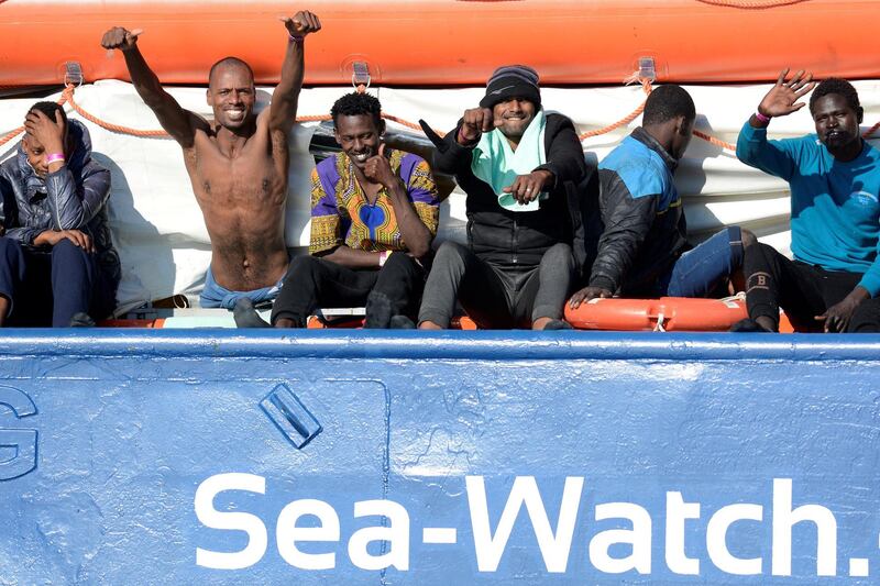 FILE PHOTO: Migrants react as they rest on board the Sea Watch 3 off the coast of Siracusa, Italy, January 27, 2019. REUTERS/Guglielmo Mangiapane/File Photo