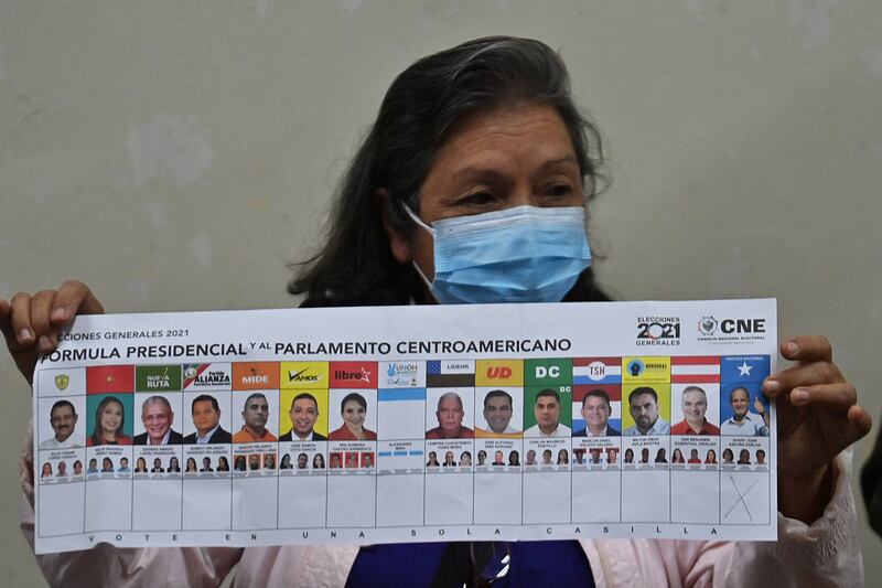 A polling official holds a ballot as votes are counted after elections in Honduras on November 28, 2021. AFP