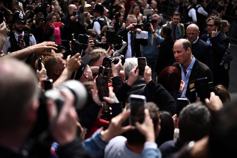 Prince William is surrounded by camera phones in Soho. AFP