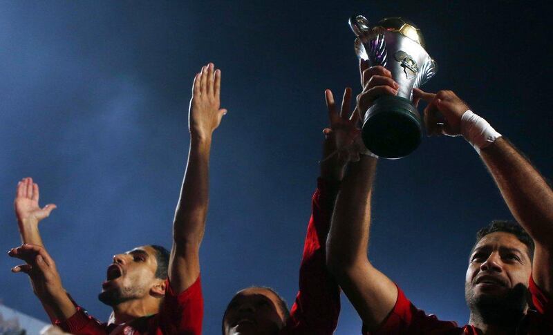 Sherif Abdel Fadil, left, of Al Ahly, celebrates with the CAF Confederation Cup trophy after Ahly's victory over Sewe Sport on Saturday. Amr Abdallah Dalsh / Reuters
