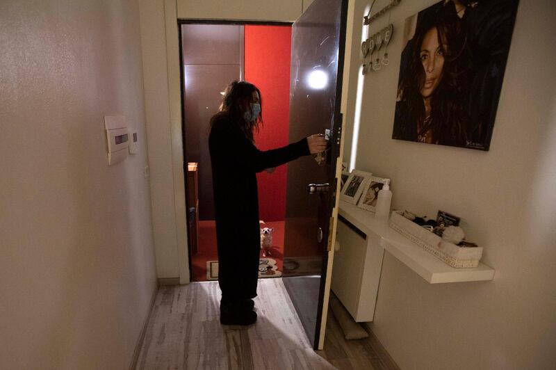 Nurse Cristina Settembrese, 54, leaves her apartment to take her dog Pepe for a walk before going to hospital for her work shift in Basiglio, Italy, April 10. Luca Bruno / AP