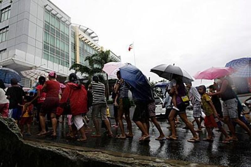 Filipino flood victims queue for food relief in Navotas city, north of Manila. Tropical Storm Kai-tak slammed the northern Philippines, triggering flash floods and killing at least two people.