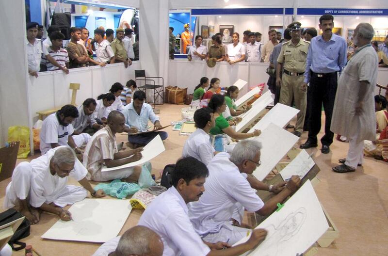 The artist Chitta Dey, standing in the beige kurta, talks to Kolkata’s commissioner of police Surajit Purakaystha, in blue, while overlooking a heavily guarded art class of convicts from the city’s Alipore jail. Courtesy West Bengal Correctional Services

