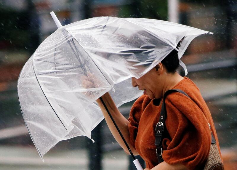 A passerby using an umbrella struggles against a heavy rain and wind as Typhoon Jongdari approaches Japan's mainland in Tokyo, Japan. REUTERS / Issei Kato