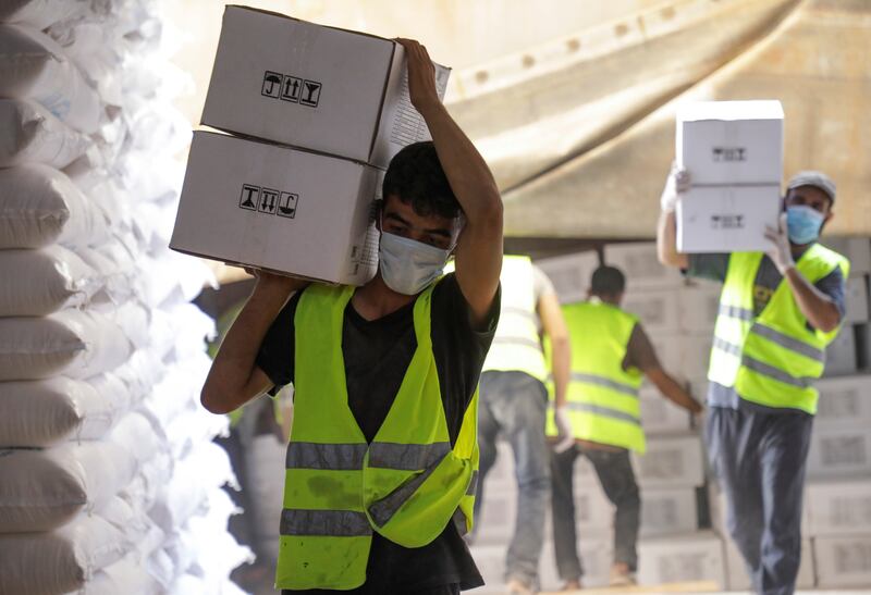 Workers carry boxes of humanitarian aid near the Bab Al Hawa crossing at the Syrian-Turkish border in Idlib. Reuters