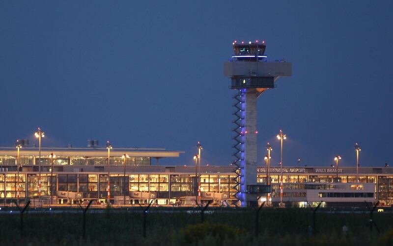 BERLIN, GERMANY - AUGUST 15: The main terminal and the control tower stand illuminated at the construction site of the new Willy Brandt Berlin Brandenburg International Airport on August 15, 2012 in Berlin, Germany. Woes for the management of airport construction are continuing, most recently with the revelation that a security worker employed at the construction site entrance is an Islamist convert named Florian L. who had contact to Islamic terrorists. Also, the FFB airport association that is in charge of the airport construction is having trouble getting further financial loans as estimated construction costs skyrocket from an orignal EUR 2.5 billion to EUR 5 billion. The airport was originally scheduled to begin operation in June, though the opening is delayed at least until March, 2013, supposedly because installation of the fire security system was far behind schedule. The new aiport is supposed to replace Berlin's current Tegel and Schoenefeld airports, though analysts say that Tegel will have to remain open because the new airport will lack sufficient capacity.  (Photo by Sean Gallup/Getty Images)