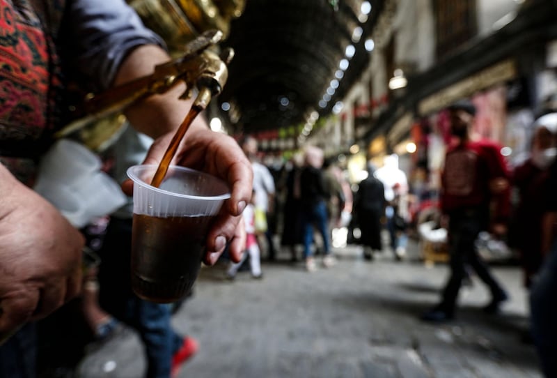 Ishaaq Kremed pours tamarind juice for a customer in Hamidiyah Souq, Damascus. AFP