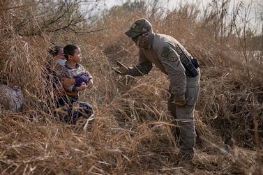 A Texas State Trooper asks asylum-seeking migrants to come out of hiding after the Honduran nationals crossed the Rio Grande into the US from Mexico, March 9, 2021. Reuters
