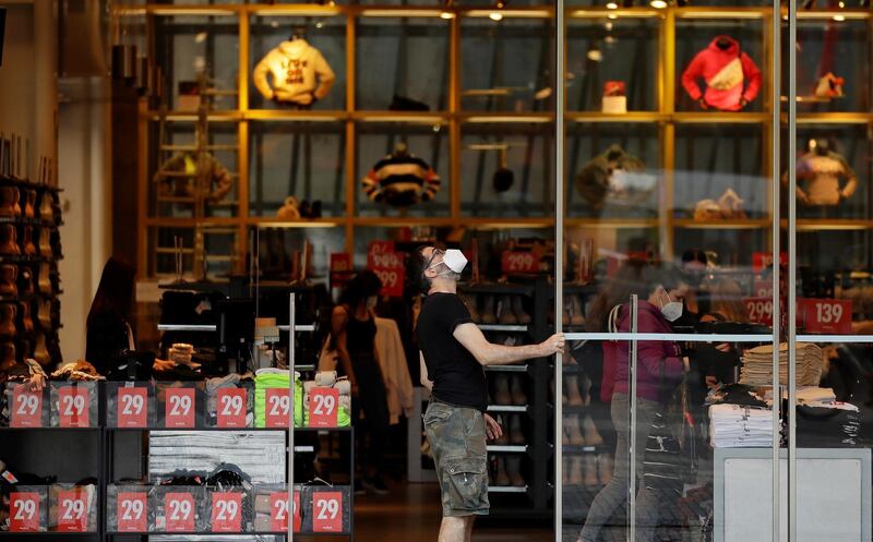 An employee opens doors of a clothing store on a first day of the re-opening of retail stores in Prague, Czech Republic. Reuters