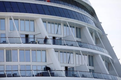 Passengers look from their balconies of the Royal Caribbean's Quantum of the Seas cruise ship, docked at Marina Bay Cruise Center after a passenger tested positive for coronavirus disease (COVID-19) during a cruise to nowhere, in Singapore, December 9, 2020. REUTERS/Edgar Su
