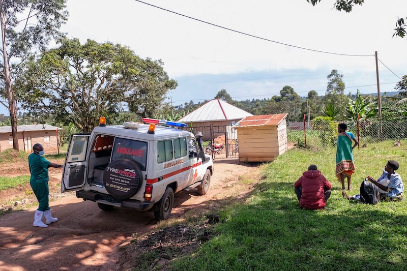 A medical officer from the Uganda Red Cross Society instructs people with suspected Ebola symptoms to enter an ambulance, in Madudu, near Mubende. AP