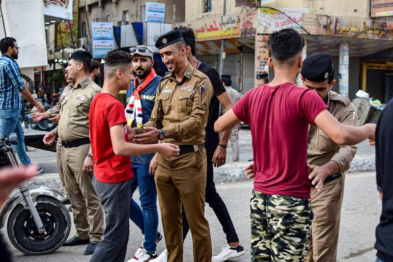 Iraqi policemen search youths on their way to attend an anti-government sit-in in Nasiriyah, the capital of the southern province of Dhi Qar.  AFP