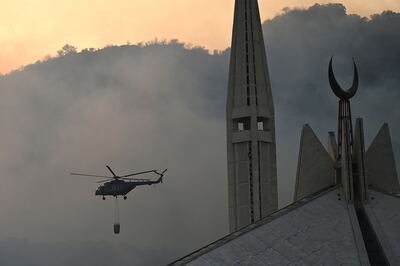 A military helicopter works to extinguish a fire that erupted in the Margalla Hills near Faisal Mosque in Islamabad, amid a heatwave. AFP