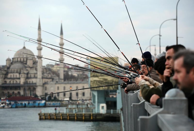 Anglers cast their lines into the waters of the Golden Horn from Istanbul's Galata Bridge. Oliver Berg/DPA via AP