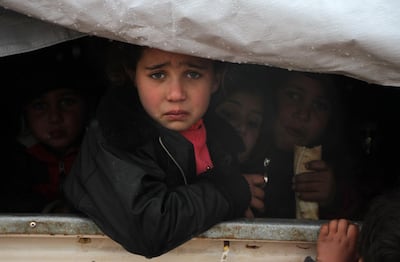 A Syrian child reacts upon her arrival in the back of a truck at a camp for displaced people near the village of Harbnoush in the Idlib province after fleeing government forces' advance on Maaret al-Numan in the south of the prvoince, on December 27, 2019. Since mid-December, regime forces and their Russian allies have heightened bombardment on the southern edge of the final major opposition-held pocket of Syria, eight years into the country's devastating war. / AFP / Aref TAMMAWI
