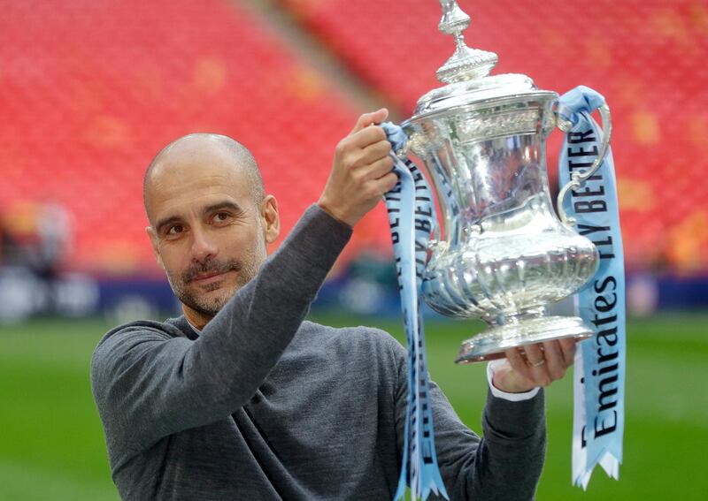 Manchester City's manager Pep Guardiola poses with the trophy after the English FA Cup Final soccer match between Manchester City and Watford at Wembley stadium in London, Saturday, May 18, 2019. (AP Photo/Kirsty Wigglesworth)