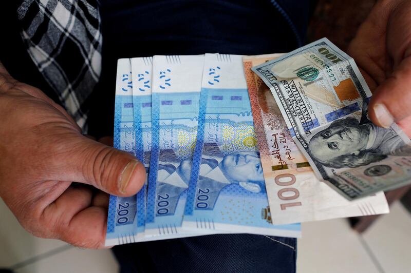 FILE PHOTO: Moroccan dirhams and U.S. dollar notes are pictured in a photo illustration in Casablanca, Morocco, June 29, 2017. REUTERS/Youssef Boudlal/Illustration/File Photo
