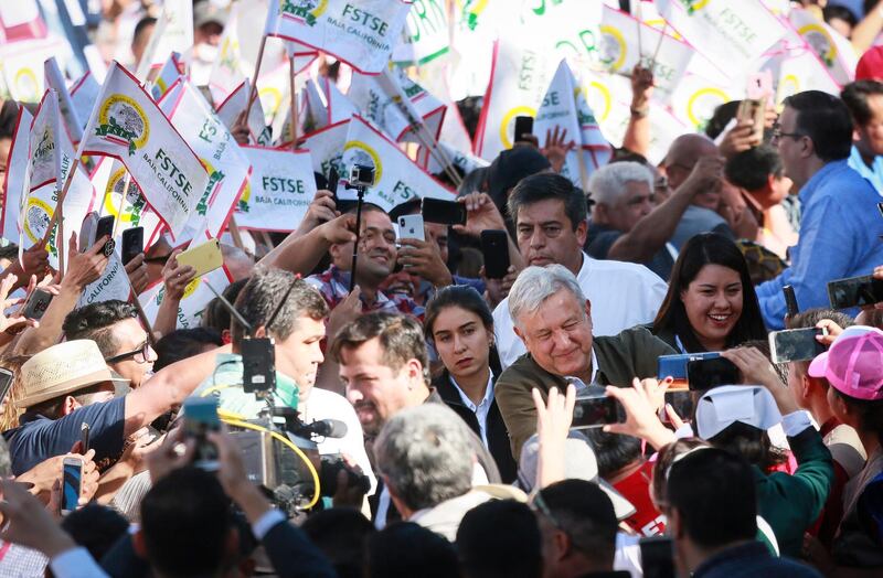 TIJUANA, MEXICO - JUNE 08: Mexican President Andres Manuel Lopez Obrador shakes hands with the crowdduring a unity rally on June 8, 2019 in Tijuana, Mexico.. Lopez Obrador committed to defending Mexicos dignity amid a looming threat from U.S. President Donald Trump, who has pledged to impose 5% tariffs on Mexican products unless the country prevents Central American migrants from traveling through its territory.(Photo by Sandy Huffaker/Getty Images)