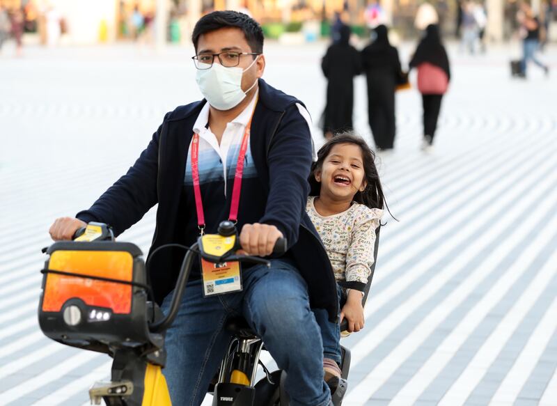 Visitors ride a bike at Expo 2020 Dubai. Cycling and walking will be a major part of the residential legacy site. Chris Whiteoak / The National