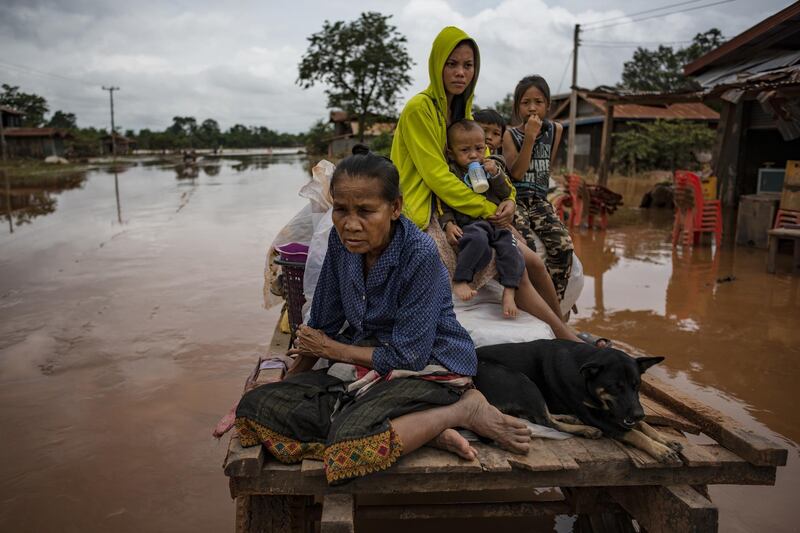 Villagers evacuate to safer grounds after flash floods engulfed their villages in Attepeu, southeastern Laos. Jes Aznar/Getty Images