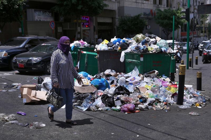 A woman walks past a pile of rubbish on a street in Beirut on July 14, 2020. AP Photo